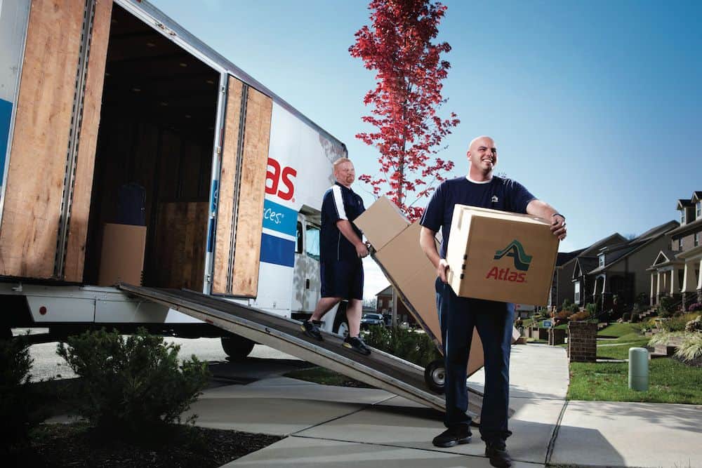 professional movers in front of moving truck with Atlas logo on box