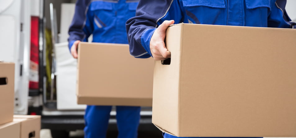 Two movers in uniform carrying boxes