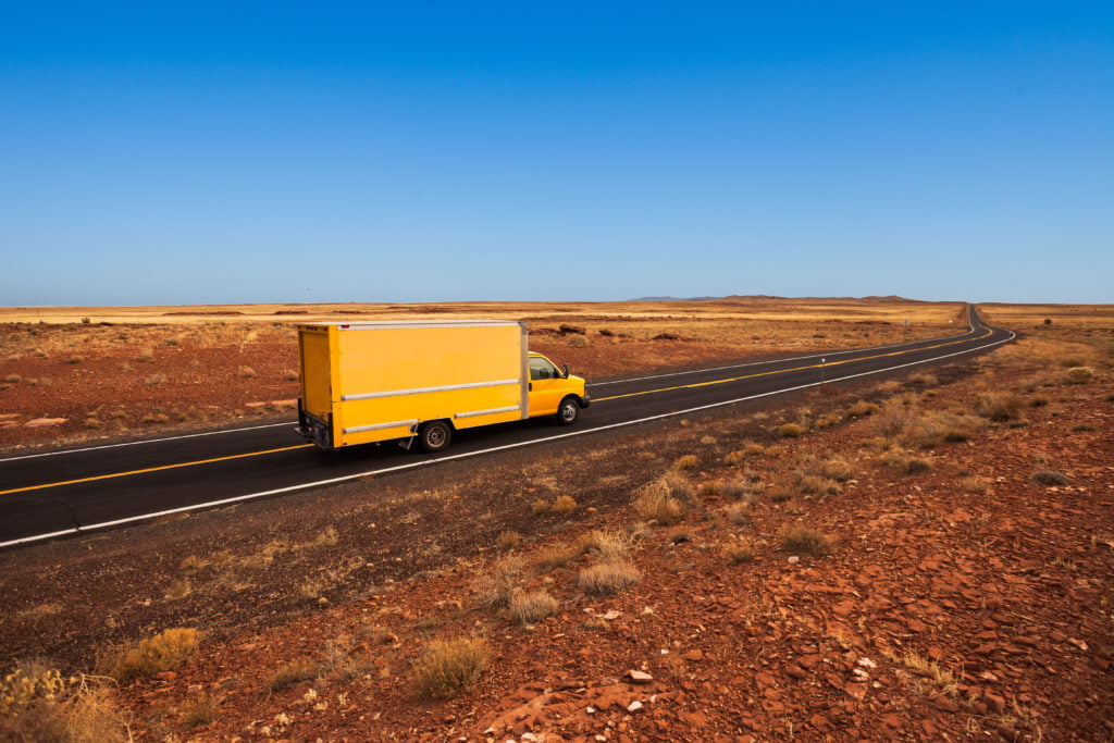 Yellow moving truck on desert highway, Arizona
