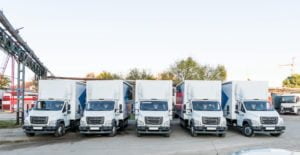 Five white truckers in the parking lot are waiting for the next delivery of goods. The concept of a transport company for the delivery of goods worldwide.