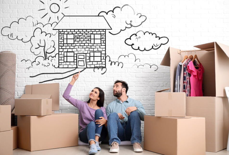 Young couple with belongings dreaming about moving into new house