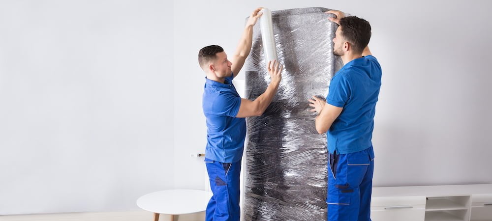 Moving Companies that Pack for you with two men Packing a Rug