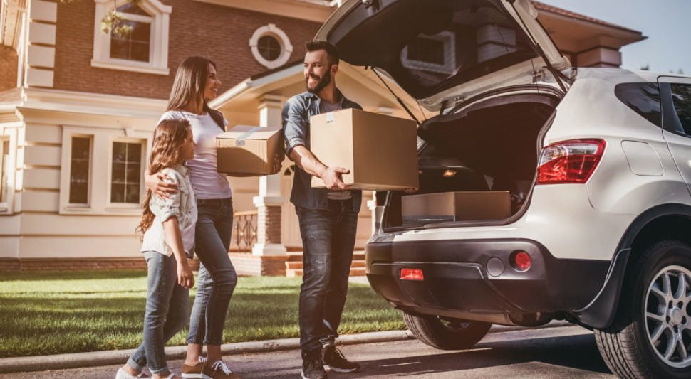 Family packing moving boxes into car