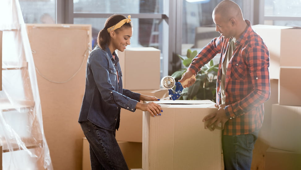 African American couple packing moving boxes