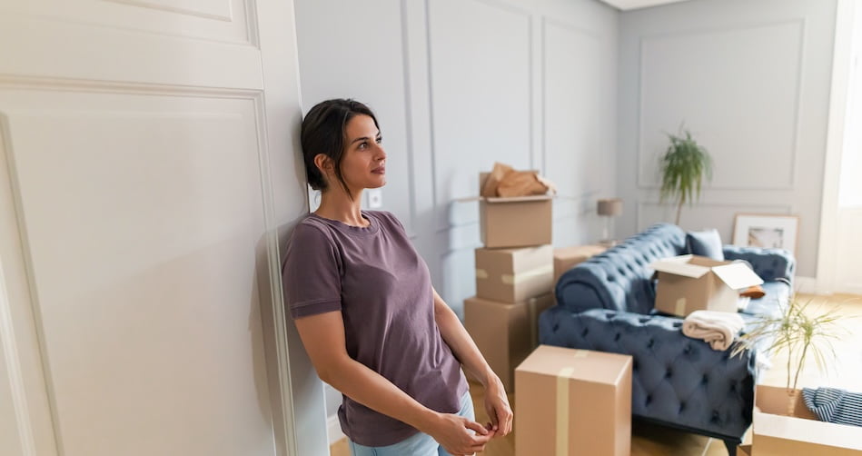 woman thinking of planning a move surrounded by boxes
