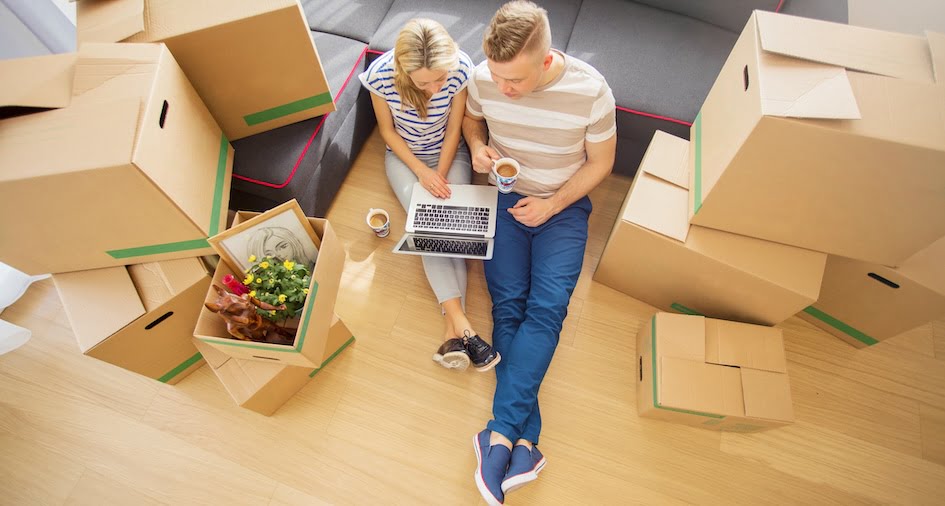 couple planning move with laptop around boxes