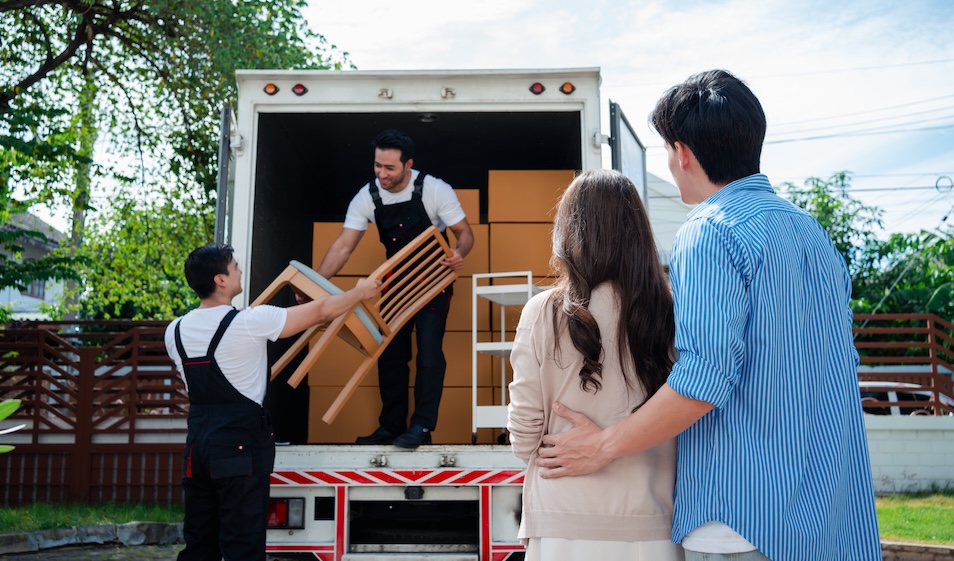 Asian Couple watching movers move from one house to another